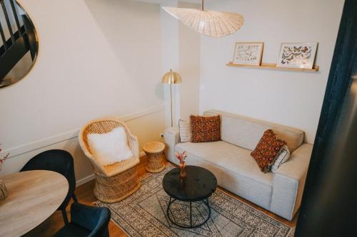 a living room with a couch and a table at Apparts' Rennes BnB Duhamel- Centre Gare in Rennes