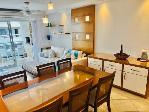 une cuisine et un salon avec une table et des chaises dans l'établissement Apto Edif viva a vida, à Bertioga