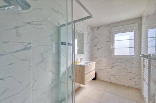 une salle de bain avec une douche en verre et un lavabo dans l'établissement Maison Corail 3 - Parking privé proche plage, à Saint-Pierre-dʼOléron