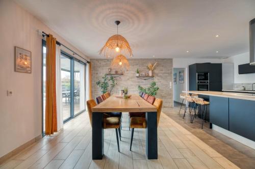 une cuisine et une salle à manger avec une table et des chaises dans l'établissement La Gragnaguaise - Maison climatisée avec piscine, à Gragnague