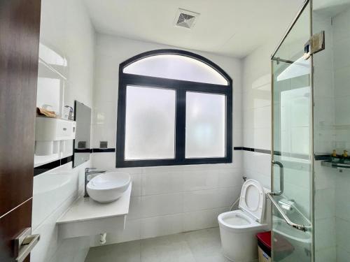 un bagno con un water, un lavandino e una finestra di Katie Homestay a Phu Quoc