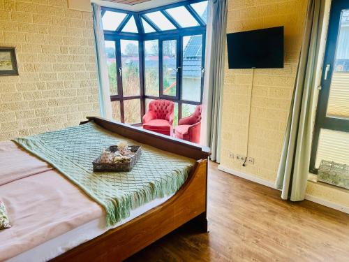 Un dormitorio con una cama y una ventana grande. en Castles Corner Bad Fallingbostel, en Bad Fallingbostel