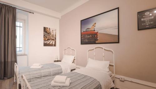 two beds in a hospital room with a picture on the wall at Vico 4 Charme Apartments in Trieste
