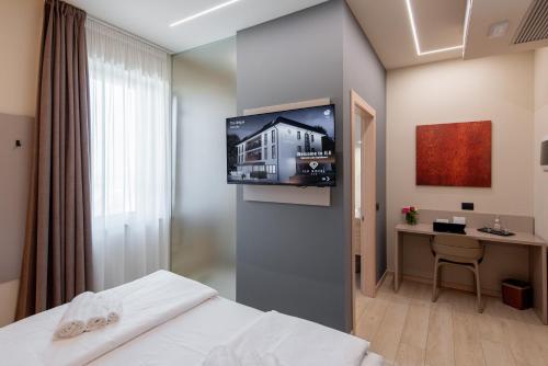 a hotel room with a bed and a tv on a wall at Ile Hotel in Peschiera del Garda