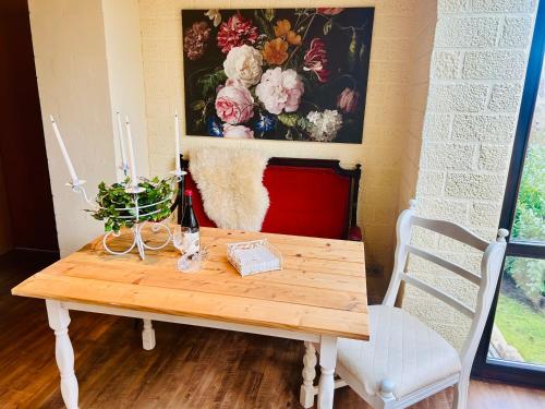 una mesa de madera con una pintura floral en la pared en Castles Corner Bad Fallingbostel, en Bad Fallingbostel