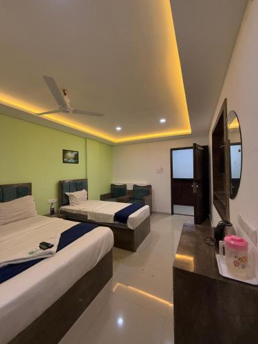 a hotel room with two beds and a couch at Queens Residency - Kochi in Ernakulam