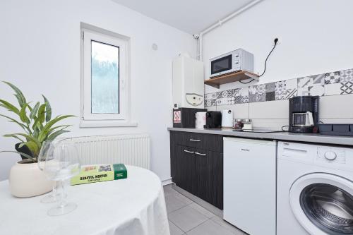 a kitchen with a washing machine and a table at Marcos Apartments - self check-in in Reşiţa