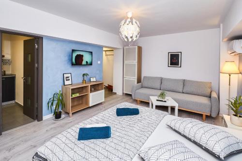 a bedroom with a large bed and a couch at Marcos Apartments - self check-in in Reşiţa