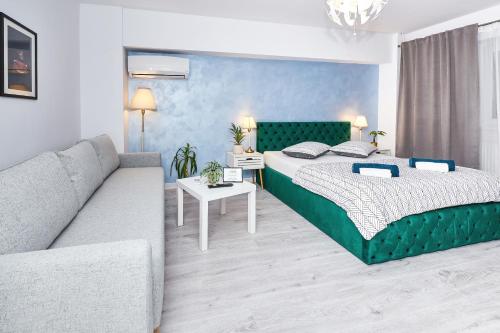 a bedroom with a large bed and a couch at Marcos Apartments - self check-in in Reşiţa