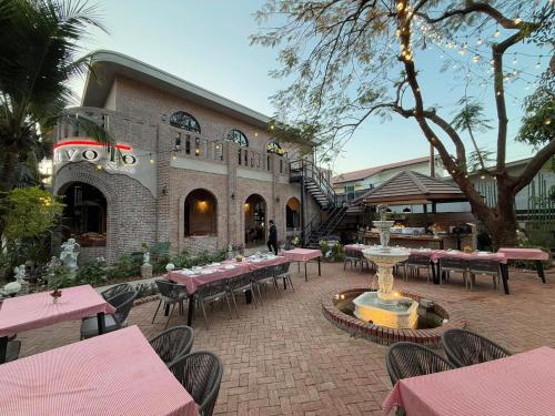 a restaurant with pink tables and chairs and a fountain at DaViKa Hotel in Vientiane