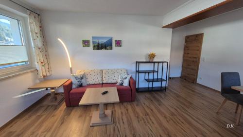 a living room with a couch and a table at Appartement Kaufmann in Westendorf