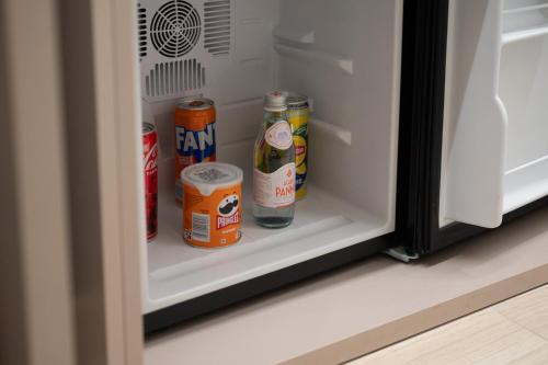 an open refrigerator with cans of food in it at Ile Hotel in Peschiera del Garda