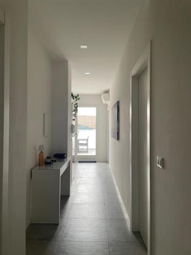 a hallway with white walls and a hallway with a table at L'attico dell'Edera in Bologna