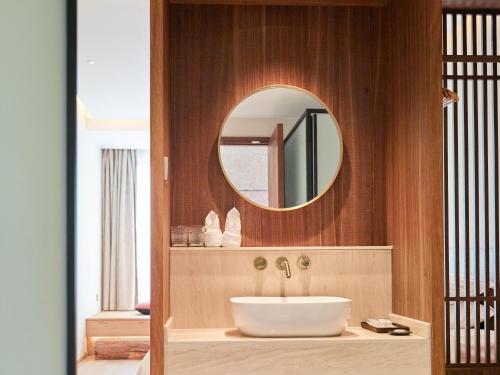 a bathroom with a sink and a mirror at Yangshuo Lisa Boutique Hotel in Yangshuo