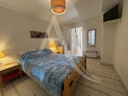 une chambre avec un lit, une table et une lampe dans l'établissement T2 en rez de jardin, face a la mer avec parking, à Sète