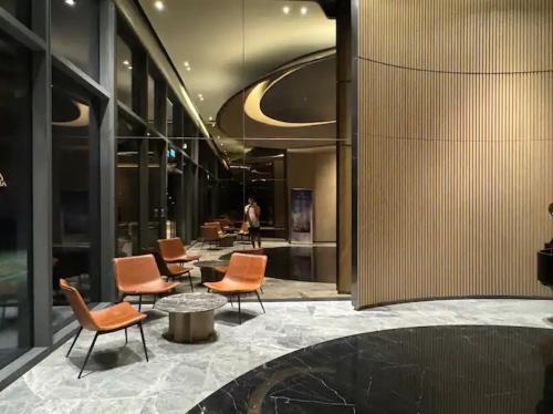 a lobby with chairs and a table in a building at THE METROPOLE Apartment Complex OPERA-GALLERIA-CREST in Ho Chi Minh City