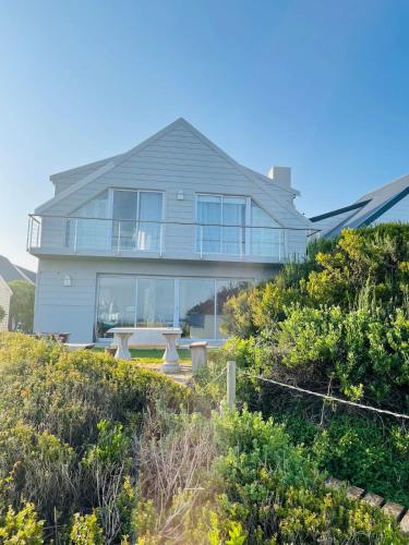 a large house with a picnic table in front of it at Africa Unwined Beach house in Witsand