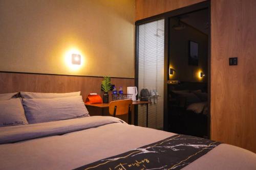 a bedroom with a bed and a desk with a table at 一间森林酒店上海外滩人民广场地铁站店 in Shanghai
