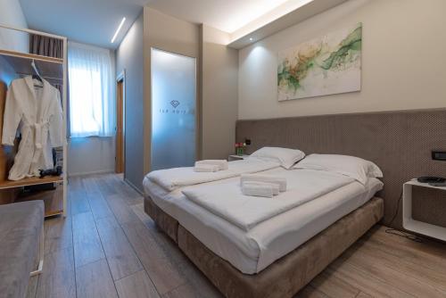 a bedroom with a large bed with white sheets at Ile Hotel in Peschiera del Garda