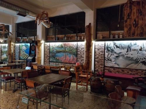 ein Restaurant mit Holztischen und Stühlen und einer Ziegelwand in der Unterkunft Elatos in Loutra Ipatis