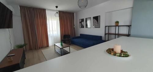 a living room with a blue couch and a table at Bella Vista Primavera 1124 in Bucharest