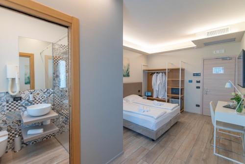 a bedroom with a bed and a bathroom at Ile Hotel in Peschiera del Garda
