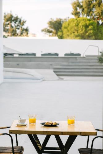 a wooden table with two glasses of orange juice at Kalisti Hotel & Suites in Fira