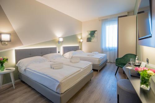 a hotel room with two beds and a television at Ile Hotel in Peschiera del Garda