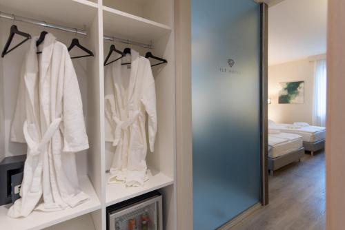 a dressing room with white robes and a mirror at Ile Hotel in Peschiera del Garda