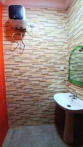 a bathroom with a sink and a tv on the wall at Budget Friendly 2bedDuplex , 15 mins to the Airport in Lagos