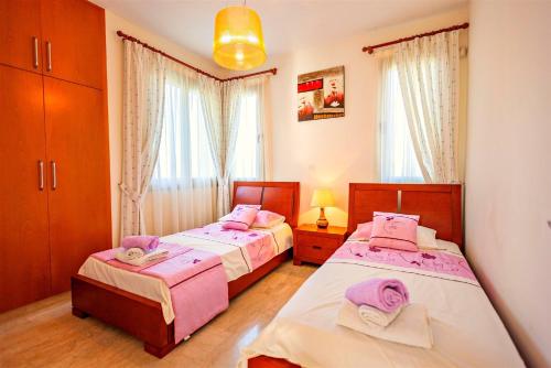a bedroom with two beds and a window at Villa Samaliana Sandy Beach Villas - Private Pool - Jacuzzi - Private Beach Area in Polis Chrysochous
