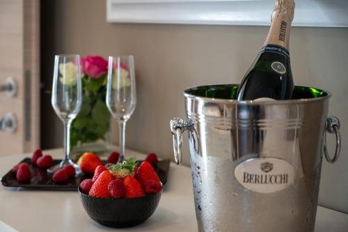 a bucket with a bottle of champagne and strawberries at Ile Hotel in Peschiera del Garda