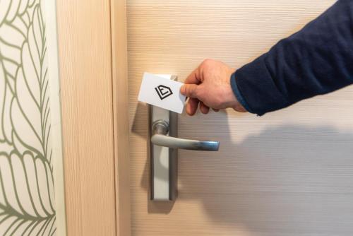 a person unlocking a door with a key at Ile Hotel in Peschiera del Garda