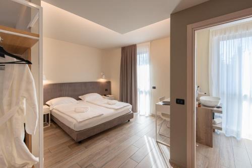 a hotel room with a bed and a bathroom at Ile Hotel in Peschiera del Garda