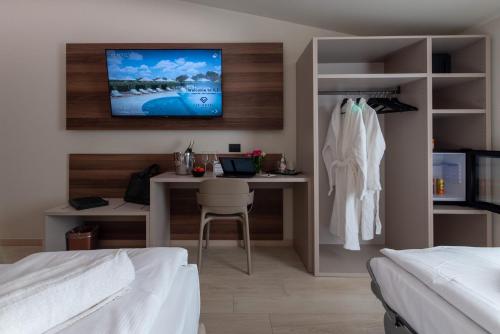 a bedroom with a desk and a tv on the wall at Ile Hotel in Peschiera del Garda