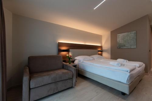 a bedroom with a bed and a chair at Ile Hotel in Peschiera del Garda
