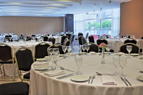 a conference room with tables and chairs with wine glasses at NH City Buenos Aires in Buenos Aires