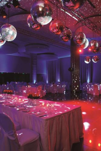 a room with a long table with chairs and chandeliers at NH City Buenos Aires in Buenos Aires