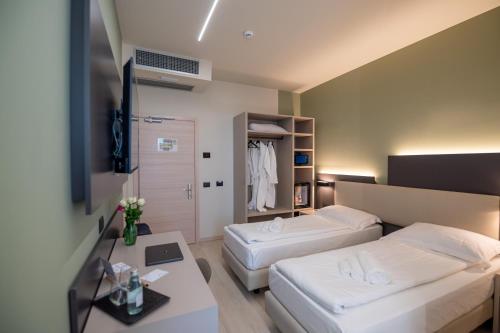 a hotel room with two beds and a table at Ile Hotel in Peschiera del Garda
