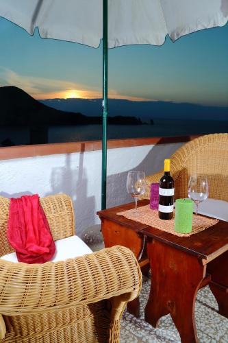 a table with two chairs and a table with wine glasses at Ammiraglio in Campese