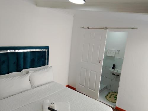 a bedroom with a bed and a bathroom with a mirror at Duminy Guest Lodge in Bellville