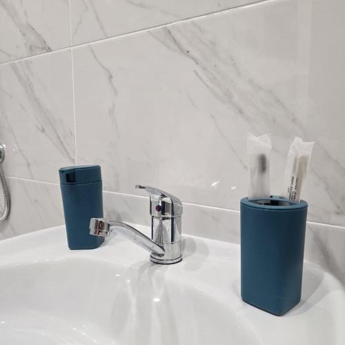 ein Waschbecken mit einem Wasserhahn und zwei Tassen darauf in der Unterkunft ЖК Панорама Парк in Qostanai