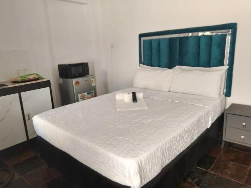 a bedroom with a bed with a remote control on it at Duminy Guest Lodge in Bellville