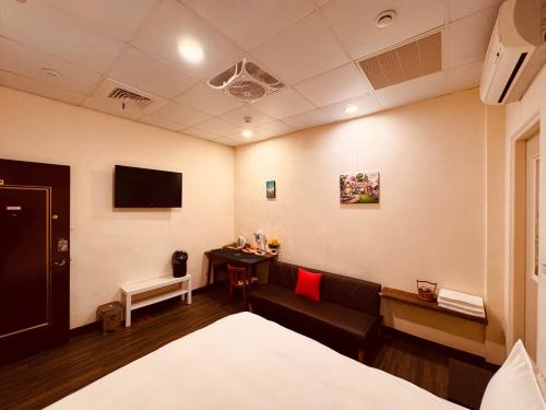 a hotel room with a couch and a tv at 安錤的家Angel's home in Nangan