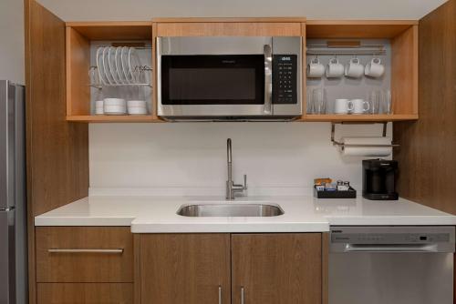 a kitchen with a sink and a microwave at Home2 Suites By Hilton Gainesville in Gainesville