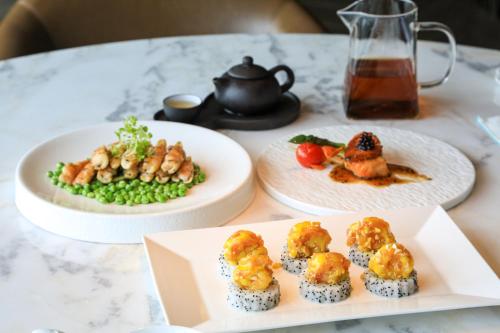 a table with two plates of food and a teapot at Beihai Marriott Resort in Beihai