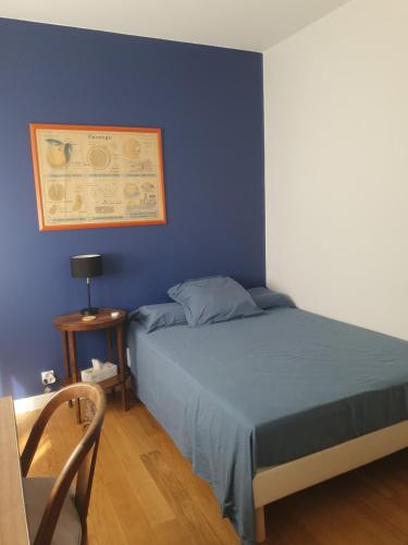 une chambre avec un lit avec un mur bleu dans l'établissement Chambre confortable dans un appartement lumineux, à Toulouse