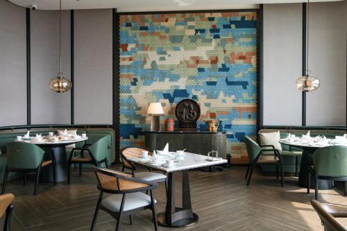 a dining room with tables and chairs and a colorful wall at Beihai Marriott Resort in Beihai