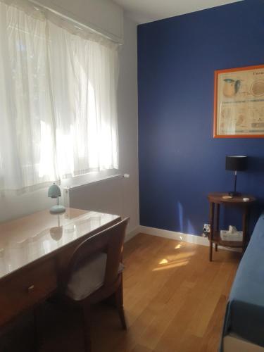 Cette chambre bleue comprend un bureau et une fenêtre. dans l'établissement Chambre confortable dans un appartement lumineux, à Toulouse