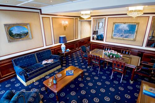 a living room on a cruise ship with a couch and tables at Grand Hotel Bristol in Stresa